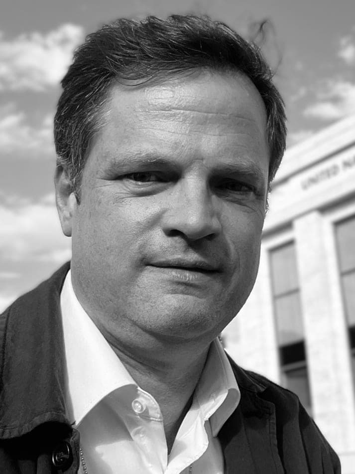Black-and-white portrait of Michael McCain outside the United Nations building.